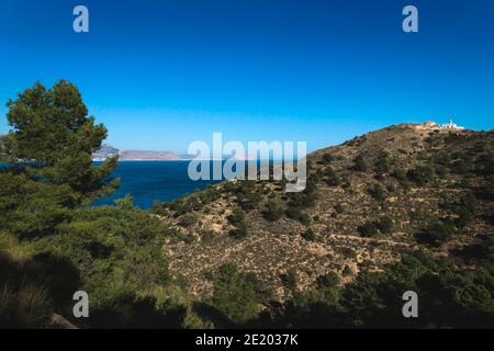 Sonniger Panoramablick auf den Naturpark 'Serra Gelada' mit Leuchtturm und dem Felsen 'Ifach' von Calpe im Hintergrund, Albir, Costa Blanca, Spanien Stockfoto