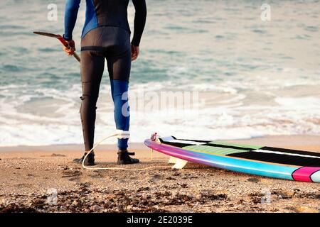 Surfer mit einem Neoprenanzug am Strand Sand bereit zum Surfen im november in Israel Stockfoto