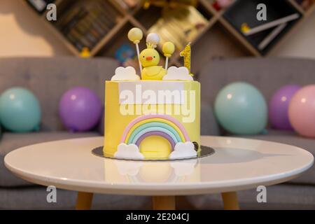 Erster Geburtstagstorte mit Hühnchen und Regenbogen. Weißer Kopierplatz auf der Vorderseite Stockfoto