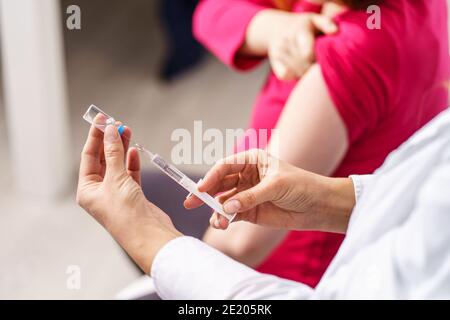 Impfung Gesundheitskonzept - Hände von Arzt oder Krankenschwester halten Eine Spritze und Ampulle, die einen Schuss Coronavirus vorbereiten Covid-19 hpv- oder Grippeimpfstoff für U Stockfoto