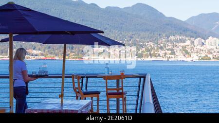 Tisch in einem Restaurant mit Blick auf das Wasser in der Innenstadt von Vancouver Harbour. Selektiver Fokus, Reisefoto, Straßenansicht Stockfoto