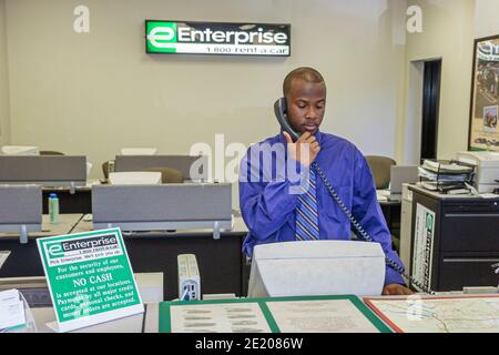 Alabama Montgomery Enterprise Rent a Car, Black man Reservationist Rezeption Mitarbeiter Schalter Telefon, Stockfoto