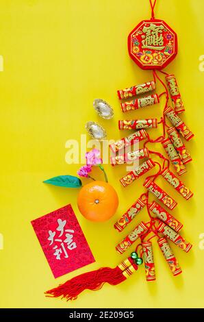 Feuerwerkskörper für chinesischen Neujahrsschmuck (Wort bedeutet Reichtum, Segen) mit Goldbarren, orangefarbenem und rotem Umschlag oder ang bao (Wort bedeutet auspi Stockfoto