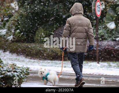 Guiyang, Chinas Provinz Guizhou. Januar 2021. Ein Bürger geht mit dem Hund im Schnee in der Stadt Guiyang, der Hauptstadt der südwestlichen Provinz Guizhou, 11. Januar 2021. Quelle: Liu Xu/Xinhua/Alamy Live News Stockfoto