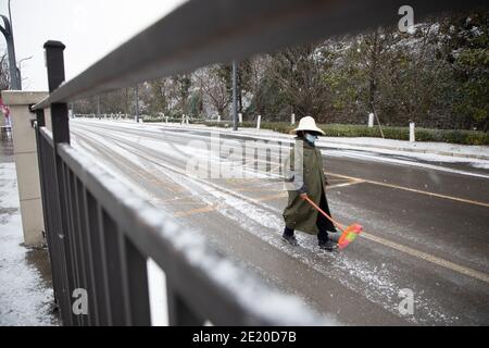 Guiyang, Chinas Provinz Guizhou. Januar 2021. Ein Sanitäter reinigt die Straße im Schnee in der Stadt Guiyang, der Hauptstadt der südwestlichen Provinz Guizhou, 11. Januar 2021. Quelle: Liu Xu/Xinhua/Alamy Live News Stockfoto