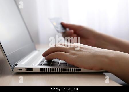 Frau mit Kreditkarten-Typen auf Laptop-Tastatur. Konzept von Online-Shopping und Zahlung, Finanztransaktionen Stockfoto