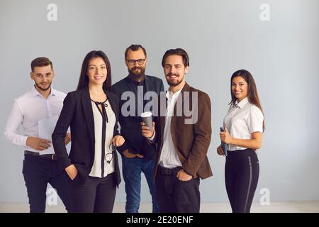 Lächelnde Geschäftsleute Büroangestellte mit Kaffee und Dokumente und Blick auf die Kamera Stockfoto