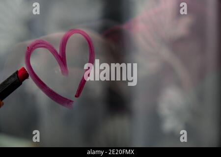 Herz auf Glas mit Lippenstift gemalt. Valentinstag. Liebe und Romantik. Herz gezeichnet von einem Lippenstift. Angezeigt. Stockfoto