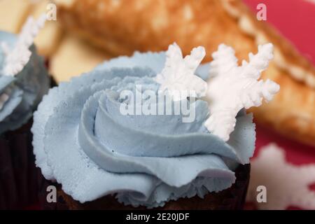 Muffin mit Frischkäse Sahne. Dekoriert mit einer Marshmallow Schneeflocke. Stockfoto