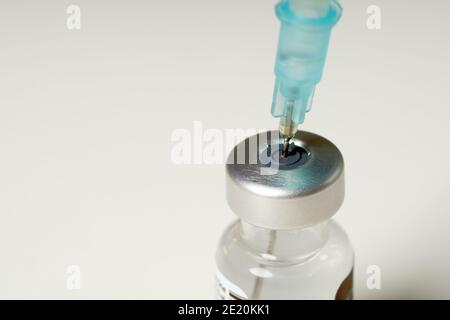 Arzt Hände injizieren eine Spritzennadel in eine kleine Flasche mit einem Impfstoff oder Medikament zuweisen Virus oder Grippe. Stockfoto