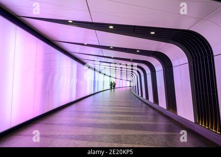 Farbenfroher Lichttunnel mit zwei Personen, die zu Fuß erreichbar sind