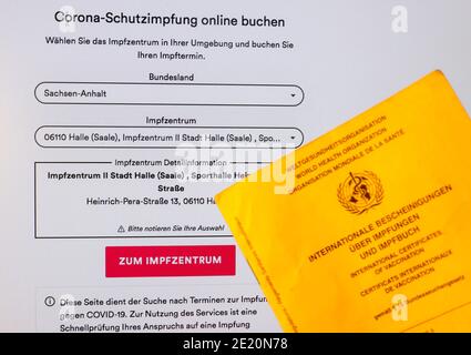 Leipzig, Deutschland. Januar 2021. Eine Hand hält eine Impfkarte vor einem Bildschirm mit der Terminvergabeseite für Corona-Impfungen. In Sachsen und Sachsen-Anhalt starten die Impfzentren am selben Tag in Betrieb. Während in Sachsen 13 Zentren beginnen, gibt es 14 in Sachsen-Anhalt. Quelle: Jan Woitas/dpa-Zentralbild/dpa/Alamy Live News Stockfoto