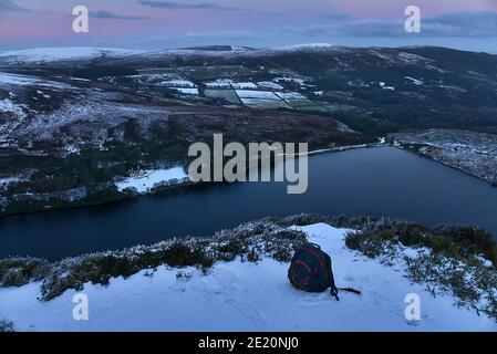 Malerische Abendaussicht über den Lough Bray Upper Lake von Eagles Crag, Ballylerane, Co. Wicklow, Irland. Reiserucksack im Vordergrund Stockfoto