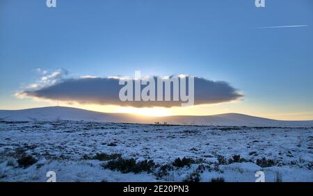 Wunderschöner Sonnenuntergang über dem Bergrücken der Wicklow Mountains in der Nähe des Kipure Peak von der Old Military Road (R115), Co. Wicklow, Irland. Schneeaktivitäten Stockfoto