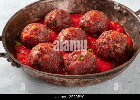 Fleischbällchen mit Tomatensoße und Petersilie, eine Nahaufnahme in einer Pfanne Stockfoto