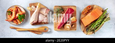 Ausgewogene Ernährung. Hauptproteine und einige Garnierungen, oben flach Lay Panorama mit Holzlöffel Stockfoto