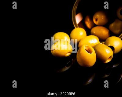Grüne Oliven in einer Blechdose auf schwarzem Hintergrund. Grüne Olivenfrüchte. Oliven Beeren. Olivenfrüchte. Gemüse und Obst. Food-Foto. Konserven. Sna Stockfoto