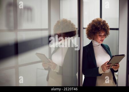 Abendaufnahme Der Schwangeren Geschäftsfrau Im Korridor Der Moderne Stehend Office Mit Digitalem Tablet Stockfoto