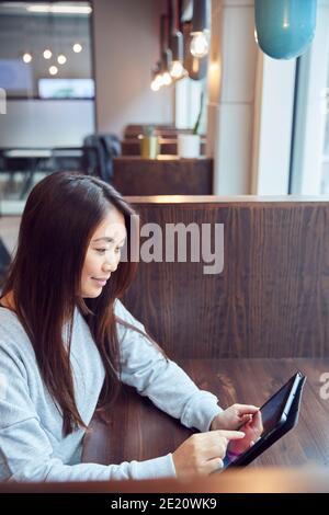 Junge Asiatische Geschäftsfrau Mit Digital Tablet In Break Out Bereich Des Modernen Büros Stockfoto