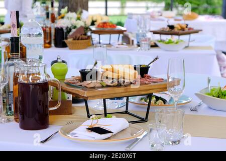 Köstliche Gerichte auf Holztabletts und Getränke auf einem Banketttisch in einem Luxusrestaurant. Stockfoto