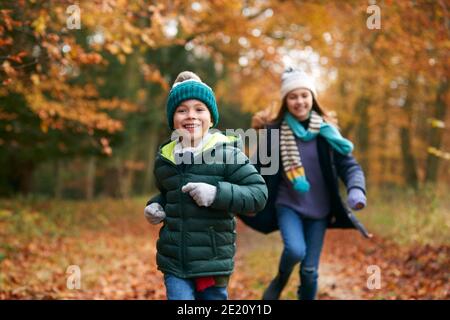 Zwei Lächelnde Kinder Haben Spaß Beim Laufen Auf Dem Weg Durch Den Herbst Gemeinsam Wald Stockfoto