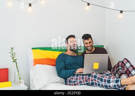 Glücklich Gay Männer paar mit Laptop im Bett- homosexuelle Liebe Und Gleichstellung der Geschlechter im Beziehungskonzept Stockfoto