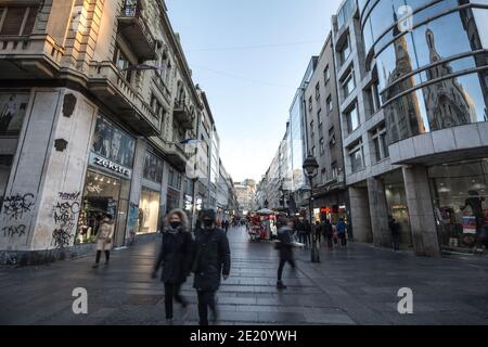 BELGRAD, SERBIEN - 6. DEZEMBER 2020: Weiße Kaukasier, die mit einer Atemmaske in der Kneza Mihailova Straße in Belgrad mit einer Geschwindigkeit laufen Stockfoto