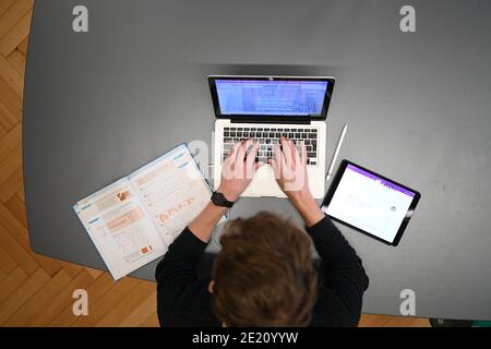 Ravensburg, Deutschland. Januar 2021. Carlos Marschall, Mathe- und Spanischlehrer an der Spohn High School, unterrichtet auf einem Laptop in der Lehrerlounge. Für Fernunterricht verwendet er sowohl Laptop als auch iPad. Quelle: Felix Kästle/dpa/Alamy Live News Stockfoto