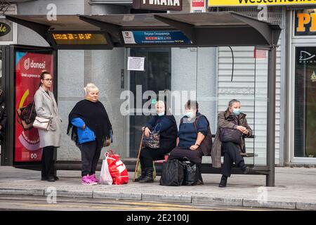 BELGRAD, SERBIEN - 17. OKTOBER 2020: Alte ältere Frau mit Atemmaske wartet auf Transport an einer Bushaltestelle von Belgrad während der coro Stockfoto