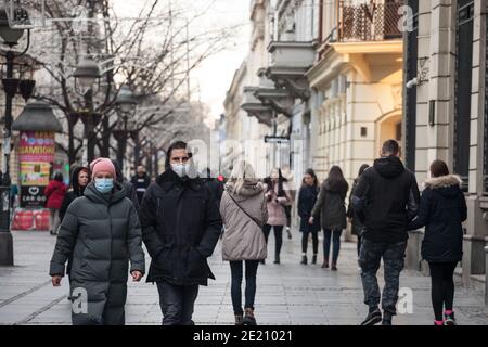 BELGRAD, SERBIEN - 12. DEZEMBER 2020: Ein Paar Verliebte, Mann und Frau gehen im Winter mit einer Atemmaske in der Kneza Mihailova Straße von Bel Stockfoto