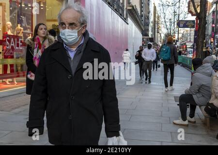 LONDON, VEREINIGTES KÖNIGREICH - 17. Dezember 2020: London, England - 17. Dezember 2020: Festliche Dekoration auf der Oxford Street. Menschen tragen Gesichtsmasken beim Gehen Stockfoto