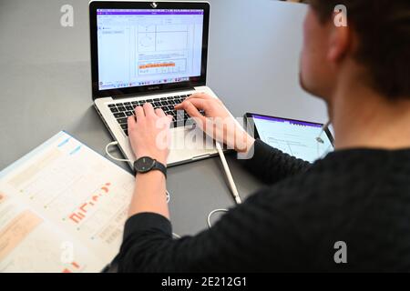 Ravensburg, Deutschland. Januar 2021. Carlos Marschall, Mathe- und Spanischlehrer an der Spohn High School, unterrichtet auf einem Laptop in der Lehrerlounge. Für Fernunterricht verwendet er sowohl Laptop als auch iPad. Quelle: Felix Kästle/dpa/Alamy Live News Stockfoto