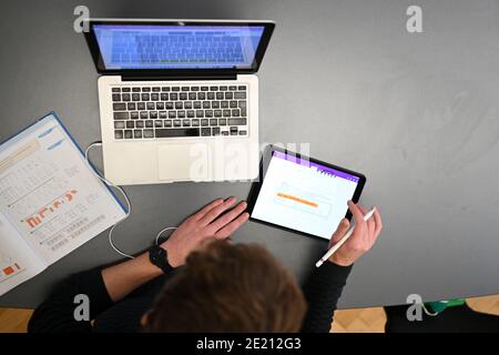 Ravensburg, Deutschland. Januar 2021. Carlos Marschall, Mathe- und Spanischlehrer an der Spohn High School, unterrichtet auf einem Laptop in der Lehrerlounge. Für Fernunterricht verwendet er sowohl Laptop als auch iPad. Quelle: Felix Kästle/dpa/Alamy Live News Stockfoto