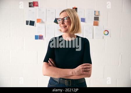 Portrait Der Reifen Frau, Die Vor Designs Steht Wand In Start Up Fashion Business Stockfoto