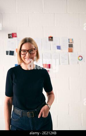 Portrait Der Reifen Frau, Die Vor Designs Steht Wand In Start Up Fashion Business Stockfoto