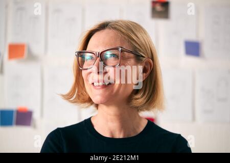 Portrait Der Reifen Frau, Die Vor Designs Steht Wand In Start Up Fashion Business Stockfoto