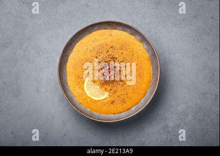 Ezogelin Suppe in grauer Schale auf Betonplatte. Türkische Küche Traditionelles Gericht mit roten Linsen, Bulgur und Reis Stockfoto