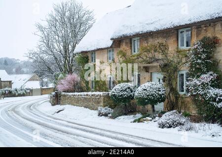 Cotswold Stein Reethäuser im Schnee zu Weihnachten. Taynton, Cotswolds, Oxfordshire, England Stockfoto