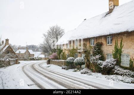 Cotswold Stein Reethäuser im Schnee zu Weihnachten. Taynton, Cotswolds, Oxfordshire, England Stockfoto