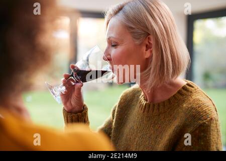 Zwei Reife Weibliche Freunde Treffen Zu Hause Zu Sprechen Und Trinken Sie Wein Zusammen Stockfoto