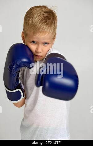 Porträt von kleinen Boxkämpfer Junge in blauen Boxer Handschuhe. Kind träumt davon, ein Boxchampion zu werden Stockfoto