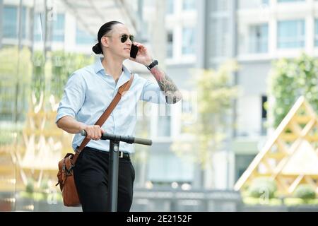 Mann auf dem Roller ruft am Telefon Stockfoto