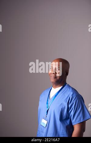 Studio Portrait Der Männlichen Krankenschwester Trägt Scrubs Stehen Gegen Grau Hintergrund Stockfoto
