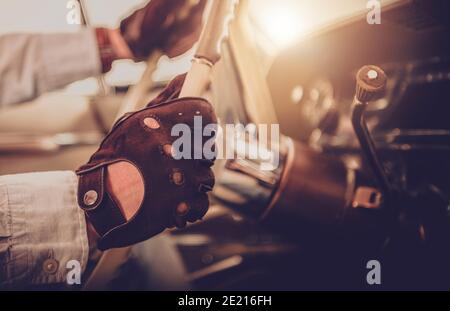 Oldtimer und Kaukasische Oldtimer Lover. Hands on Classic Car Lenkrad Nahaufnahme. Geschichte des Automotive Concept. Stockfoto