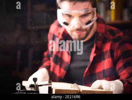 Zimmermann beschäftigt sich mit der Verarbeitung von Holz am Sägewerk aus der Nähe Stockfoto