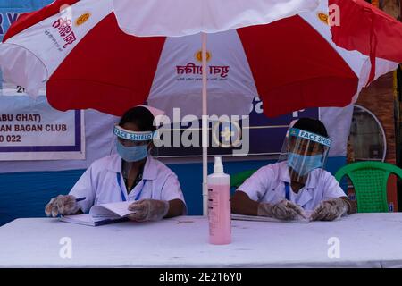 Kolkata, Westbengalen, Indien. Januar 2021. Staatliche Gesundheitsarbeiter sind auf dem Boden der Gangasagar Messe. Gangasagar Messe ist eine heilige jährliche Gemeinde von hinduistischen Pilgern. Diese findet auf der Insel Sagar statt, die am Zusammenfluss des Flusses Ganga und der Bucht von Bengalen liegt. Am Tag des "Sakar Sankranti" (14. Januar) nehmen Pilger an diesem Zusammenfluss ein heiliges Bad. Aufgrund der anhaltenden Pandemie-Situation ist das ganze unter starken COVID19-Protokollen eingeschränkt. In diesem Jahr sind die Hauptziele der Regierung regelmäßige Gesundheits-Check-up, Sanitierung des Ortes, Vermeidung von Menschenmengen etc. (Bild der Quelle: Stockfoto