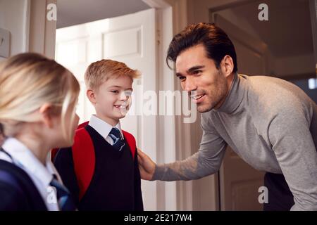 Vater Und Kinder Machen Sich Bereit, Das Haus Zur Schule Zu Verlassen Am Morgen Bei Der Tür Stehen Stockfoto