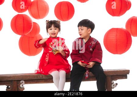 Glückliche Jungen und Mädchen mit roten Umschlägen Stockfoto