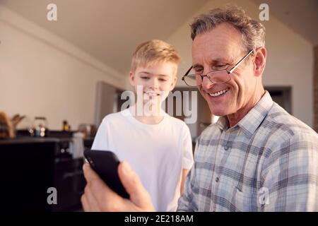 Enkel Großvater Zeigen Wie Man Das Problem Löst Und Mobile Benutzt Telefon Zu Hause Stockfoto