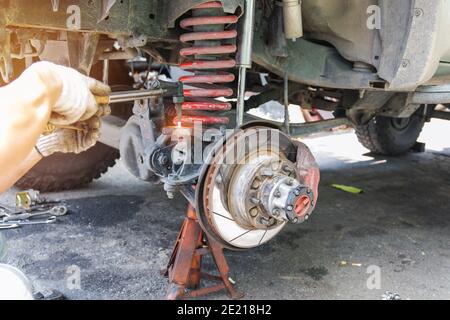 Kfz-Reparaturarbeiter verwenden Heißgas, um das Fahrwerk, die Automobilindustrie und Garagenkonzepte zu reparieren. Stockfoto